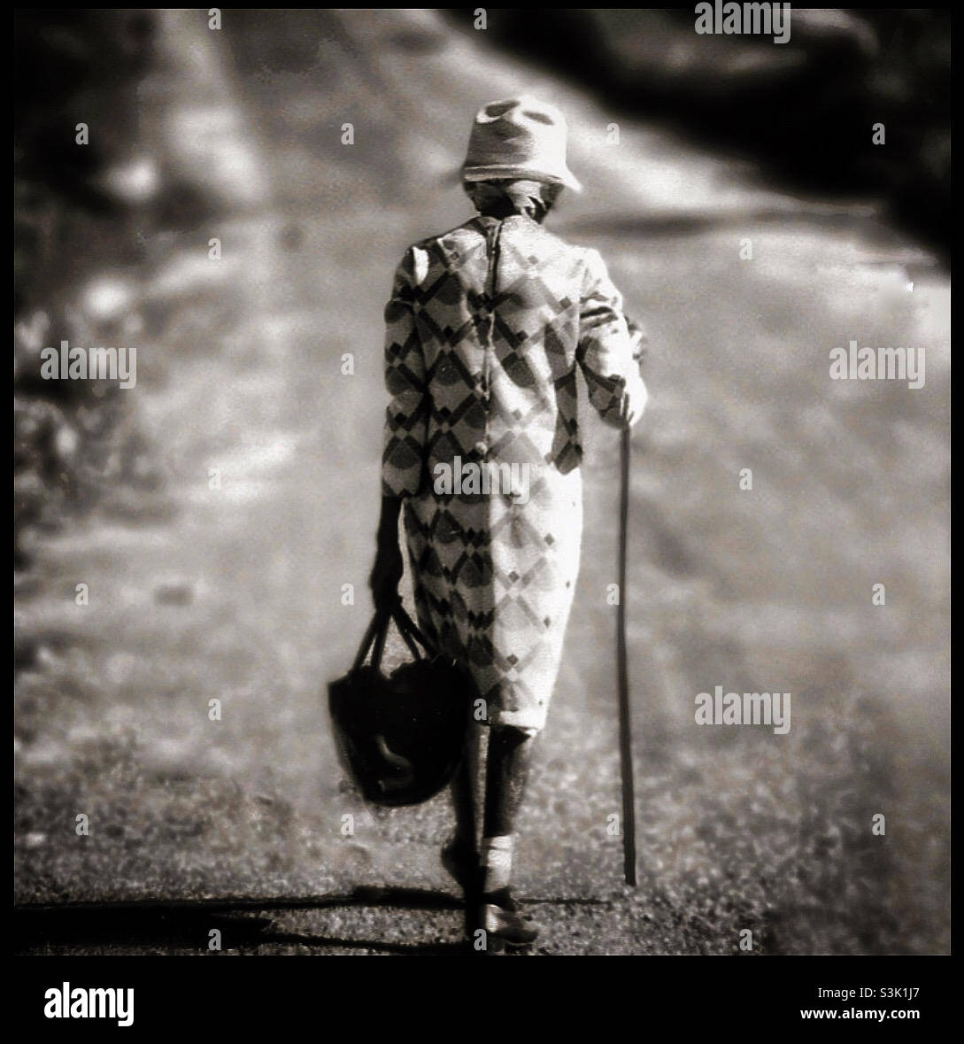 An elderly Jamaican woman walking in Jamaica with a stick. - Smartphone Captured Stock Image