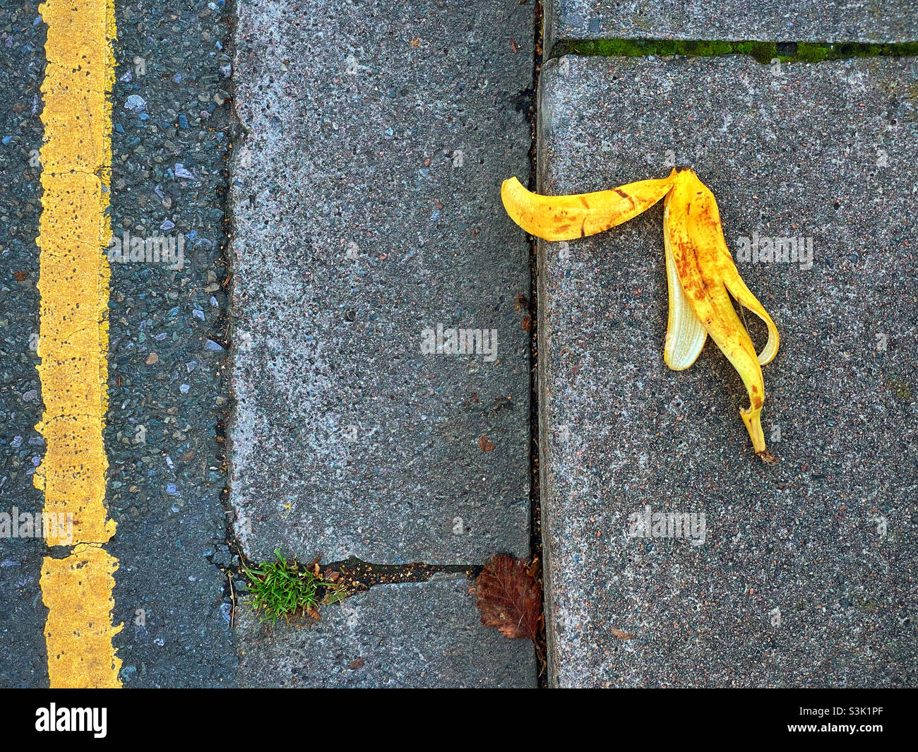 Beware slippery discarded banana peel on a walkway. If you slip on a banana skin you’ll probably look a fool and damage yourself. Photo ©️ COLIN HOSKINS. - Smartphone Captured Stock Image
