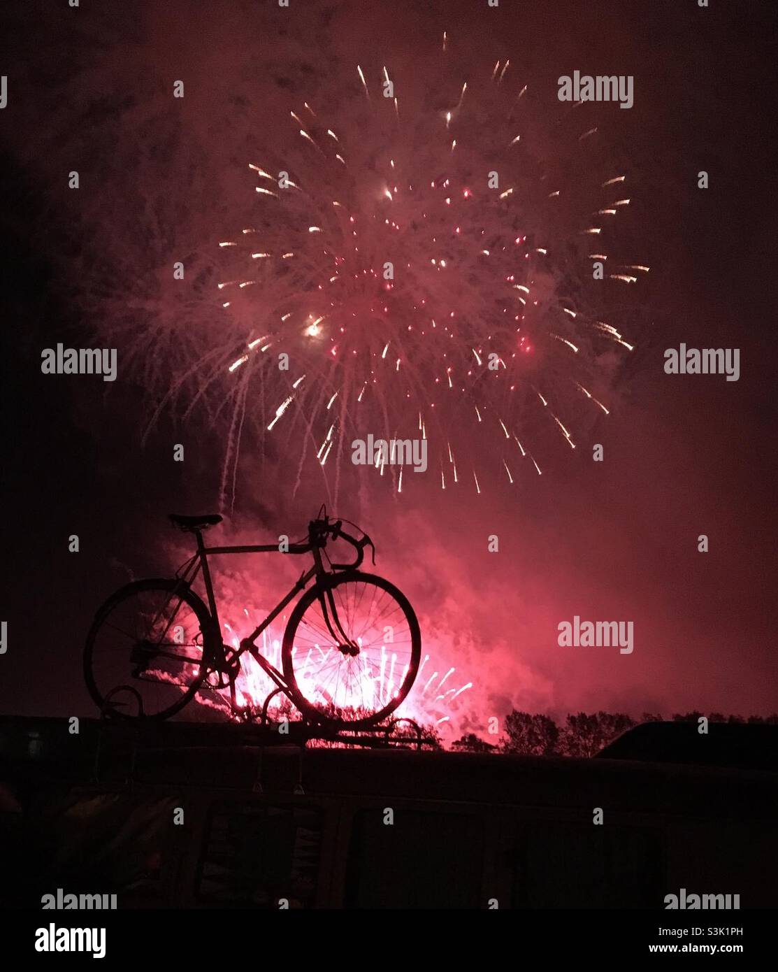 My bicycle silhouetted by fireworks at the Goodwood Members Meeting Stock Photo
