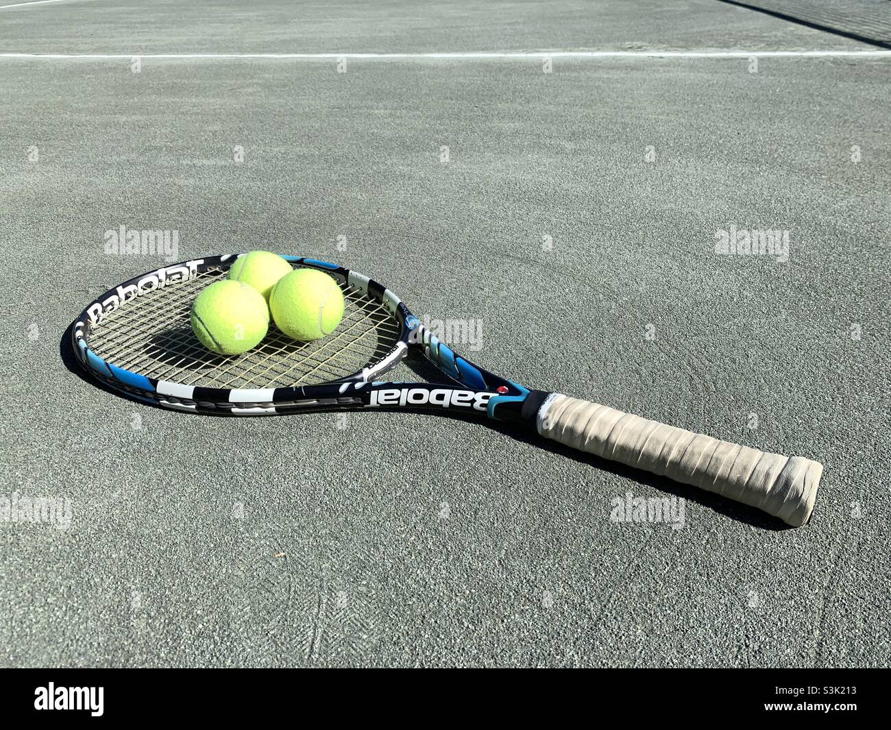 Tennis balls lying in the tennis racket with blue and white. - Smartphone Captured Stock Image