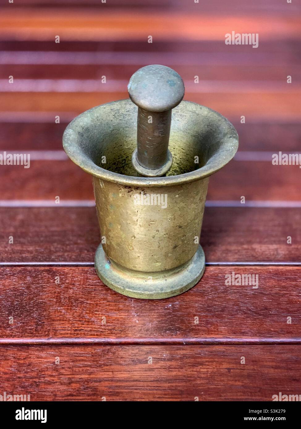 Brass mortar and pestle on a timber floor Stock Photo Alamy