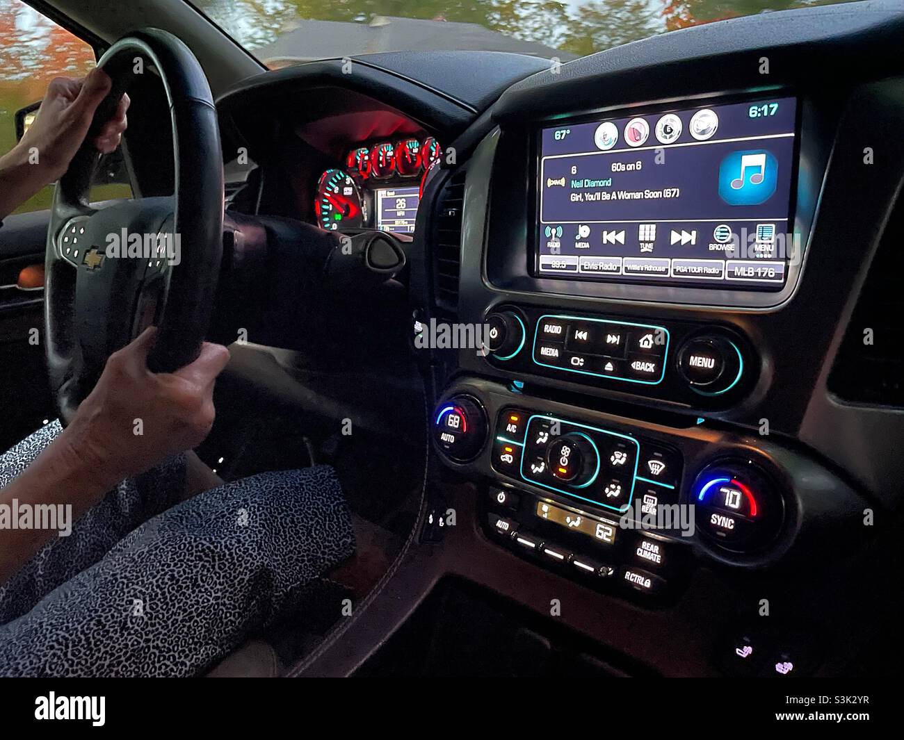 Woman driving a Chevy Tahoe SUV in the early evening, 2021, USA - Smartphone Captured Stock Image