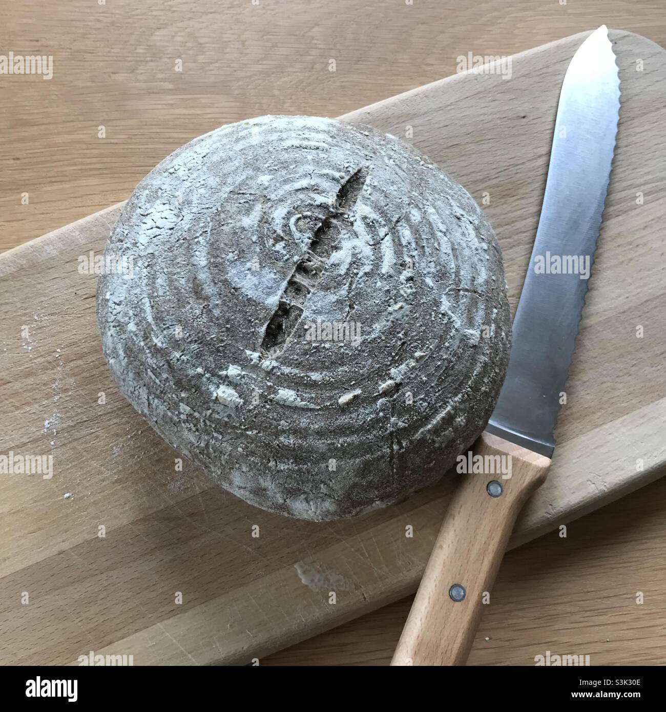 Wholemeal sourdough loaf and bread knife Stock Photo