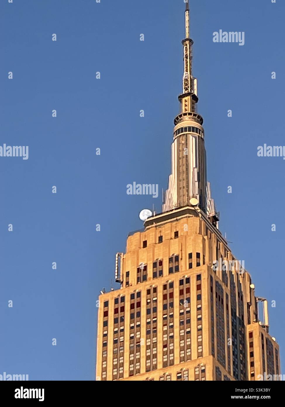 In the early morning light the moon approaches the top of the Empire State building - Smartphone Captured Stock Image