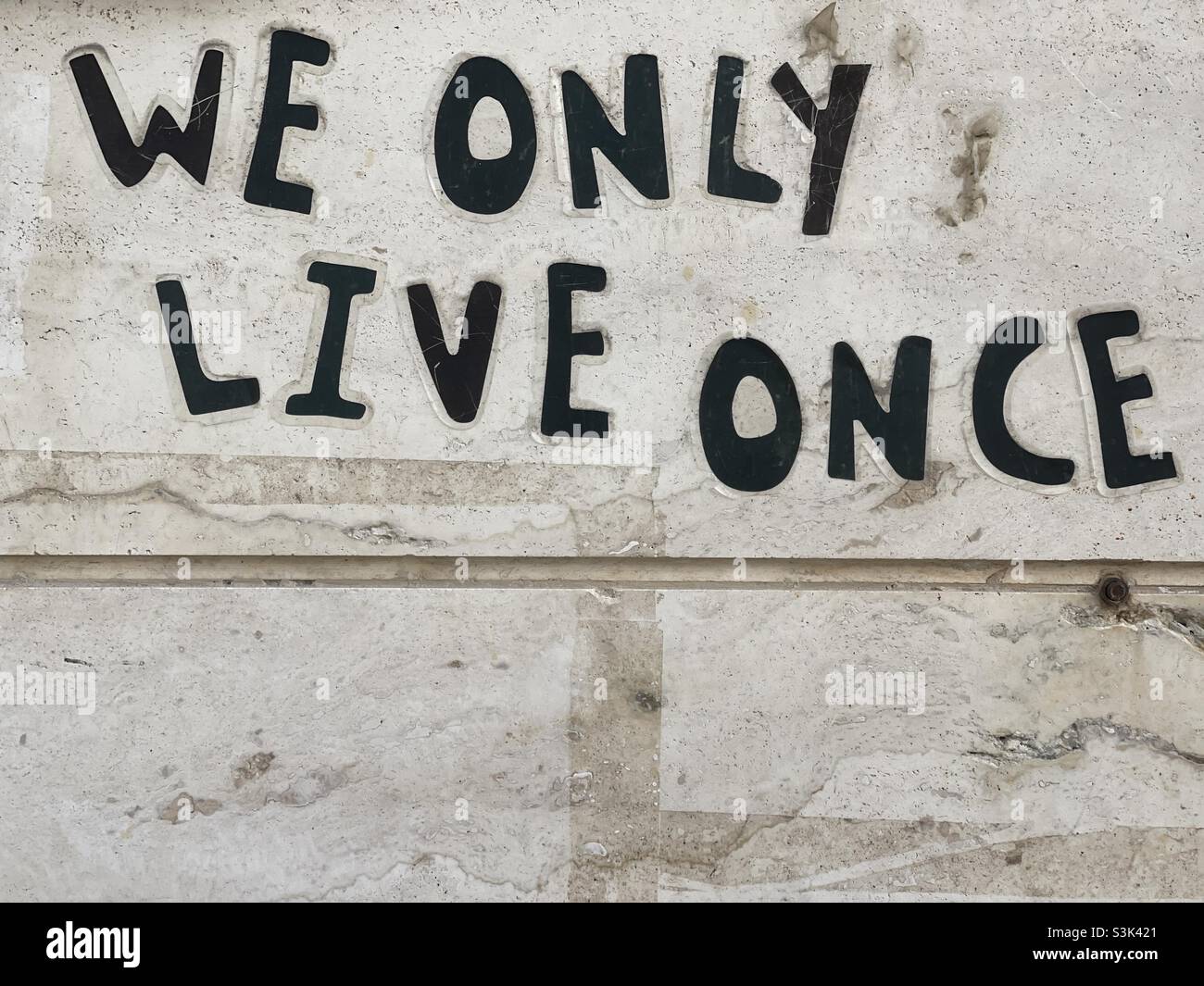 We only live once, life quote written on a wall Stock Photo