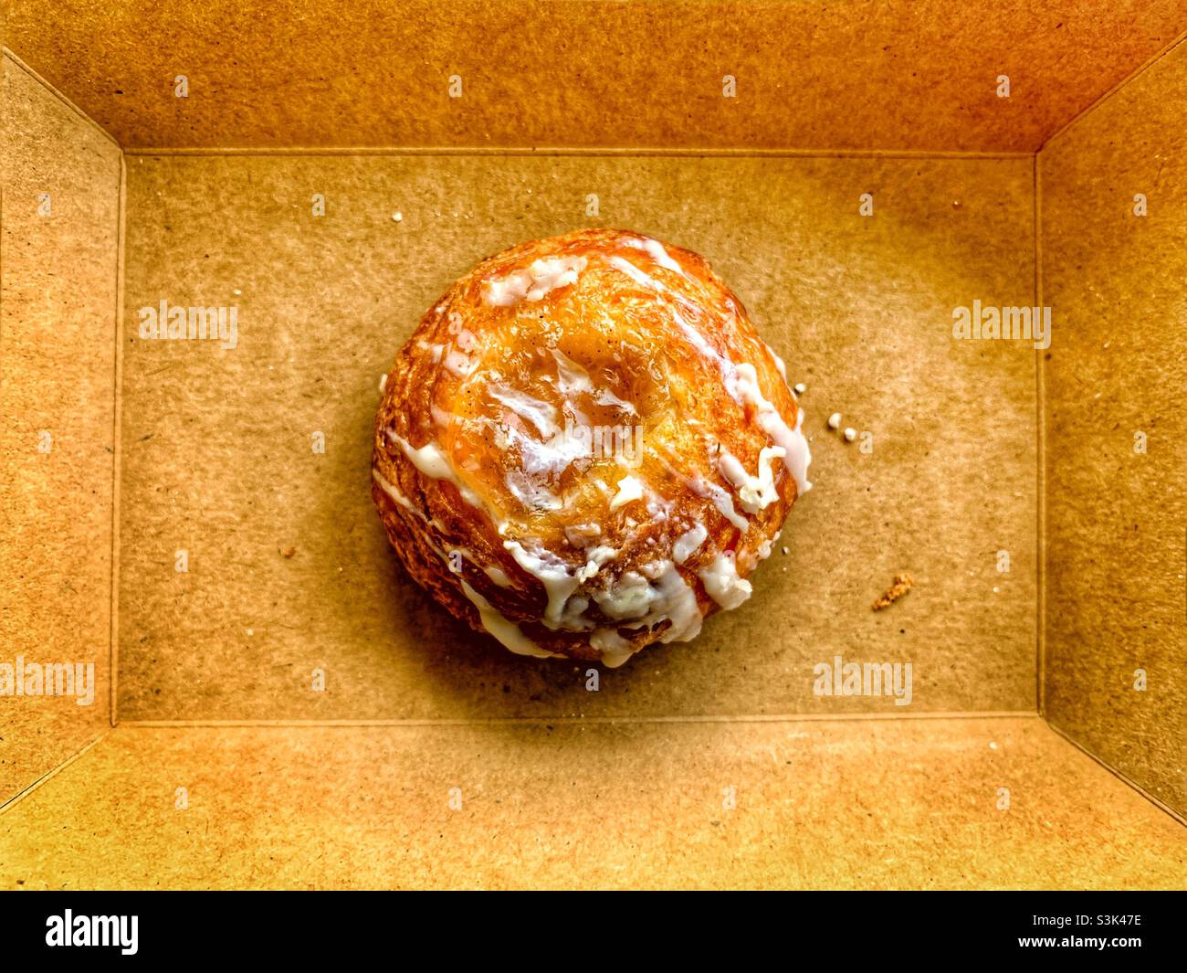 One piece danish bread with frosting, with brown background. - Smartphone Captured Stock Image
