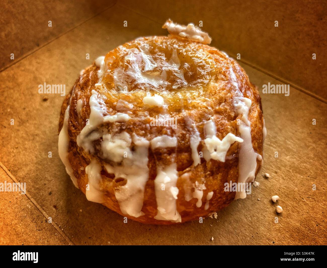 one piece close up danish bread with frosting, with brown background. - Smartphone Captured Stock Image