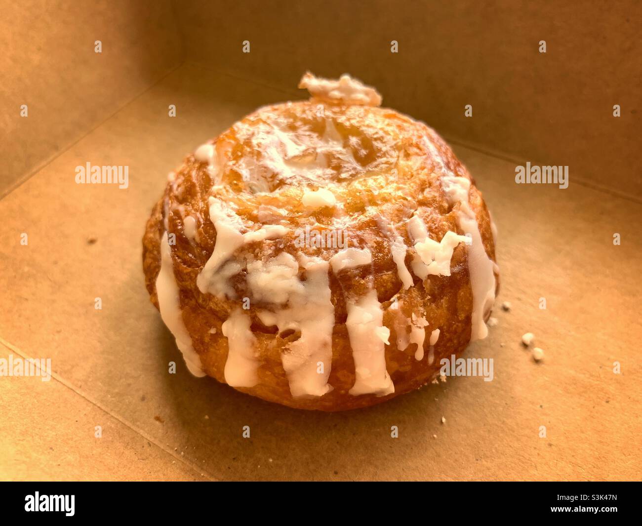 one piece close up danish bread with frosting, with brown background. - Smartphone Captured Stock Image