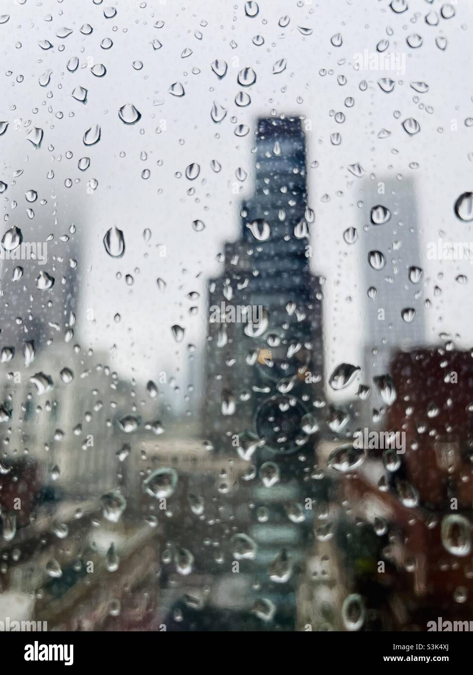 Raindrops on the window with the blurred background of New York City skyscrapers Stock Photo