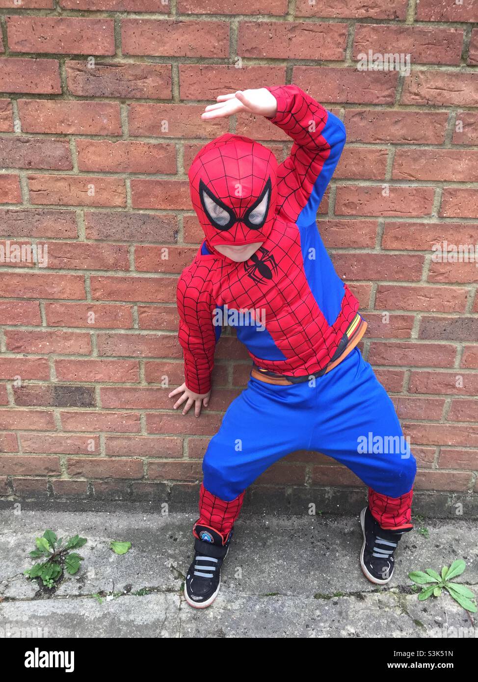 Young boy dressed as spider man and posing Stock Photo