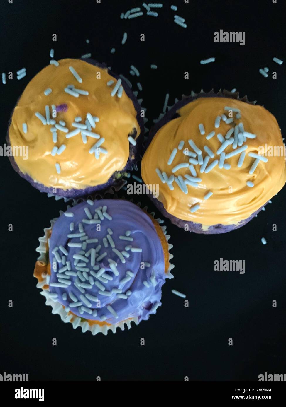Halloween holiday cupcakes with orange and purple frosting and sprinkles on top Stock Photo