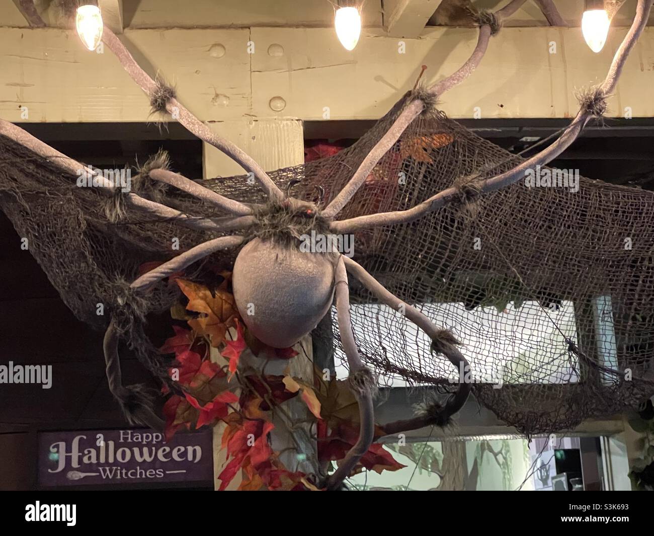 A giant spider decoration adorns a shopfront as part of Gardner Village’s annual “WitchFest” in the Salt Lake valley, Utah, USA. - Smartphone Captured Stock Image