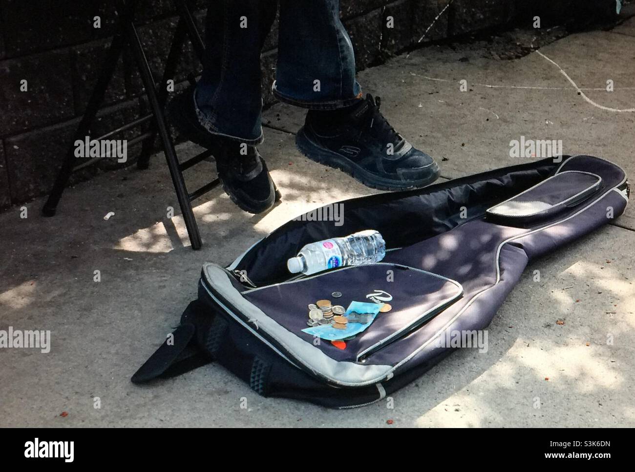 Street photography, Kensington in Calgary, Alberta , entertainer, busker, musician, guitar player, singer , guitar case, cash, money - Smartphone Captured Stock Image