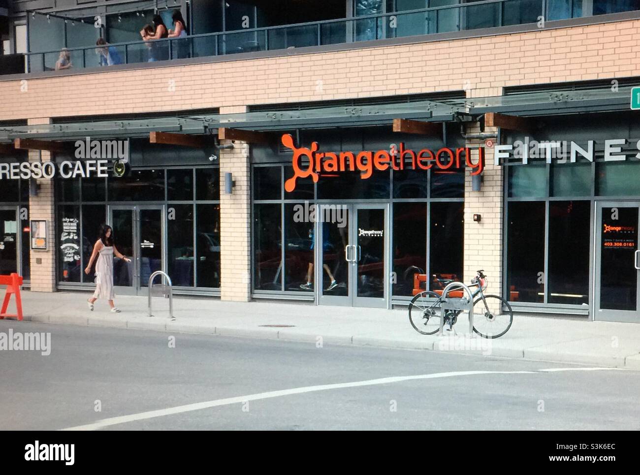 Street photography, Kensington, Calgary, Alberta , 10 street, guitar, apartment, condo, street, bicycle, woman walker, cafe, - Smartphone Captured Stock Image