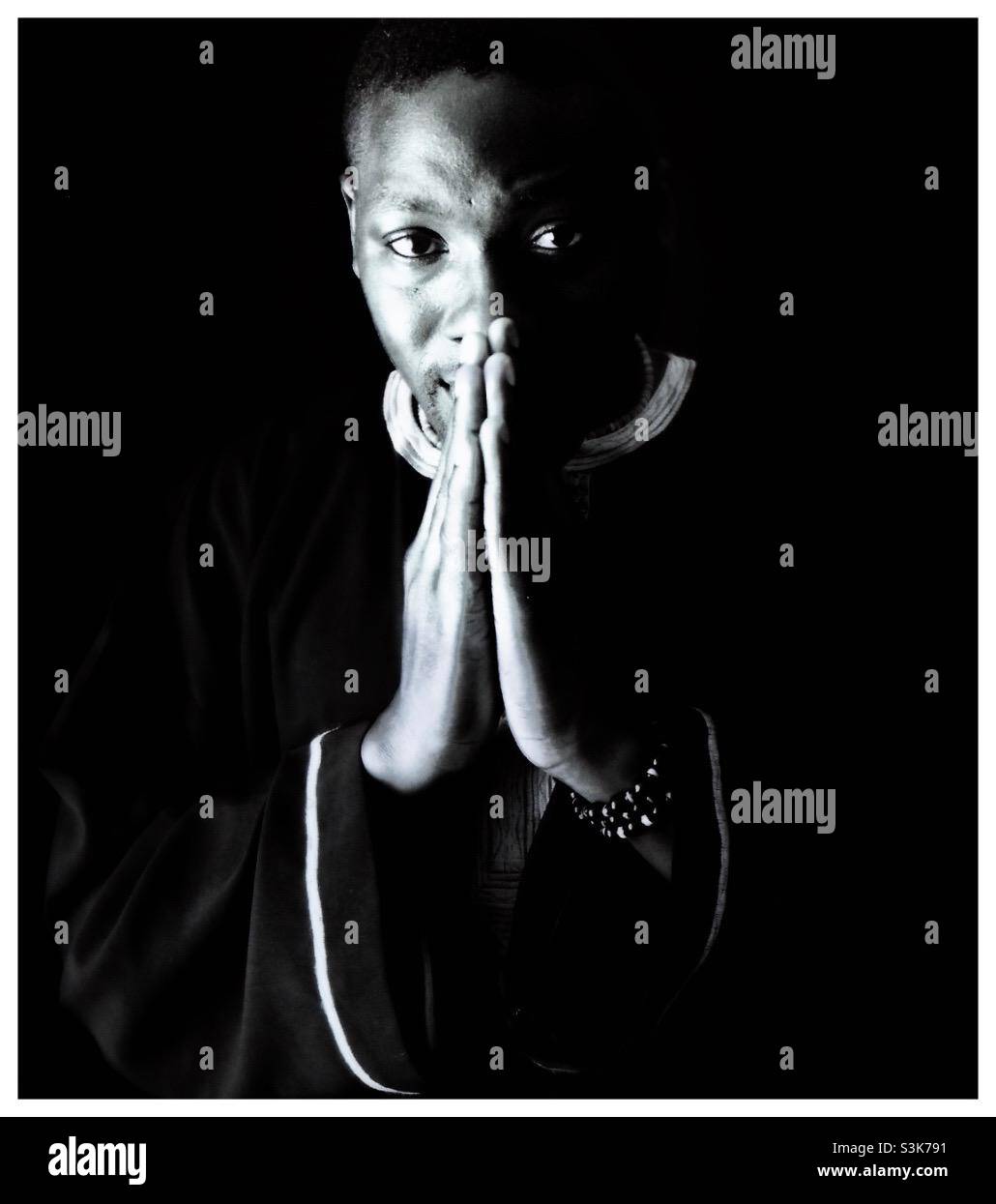 Portrait of an African man in national dress with hands clasped.. - Smartphone Captured Stock Image