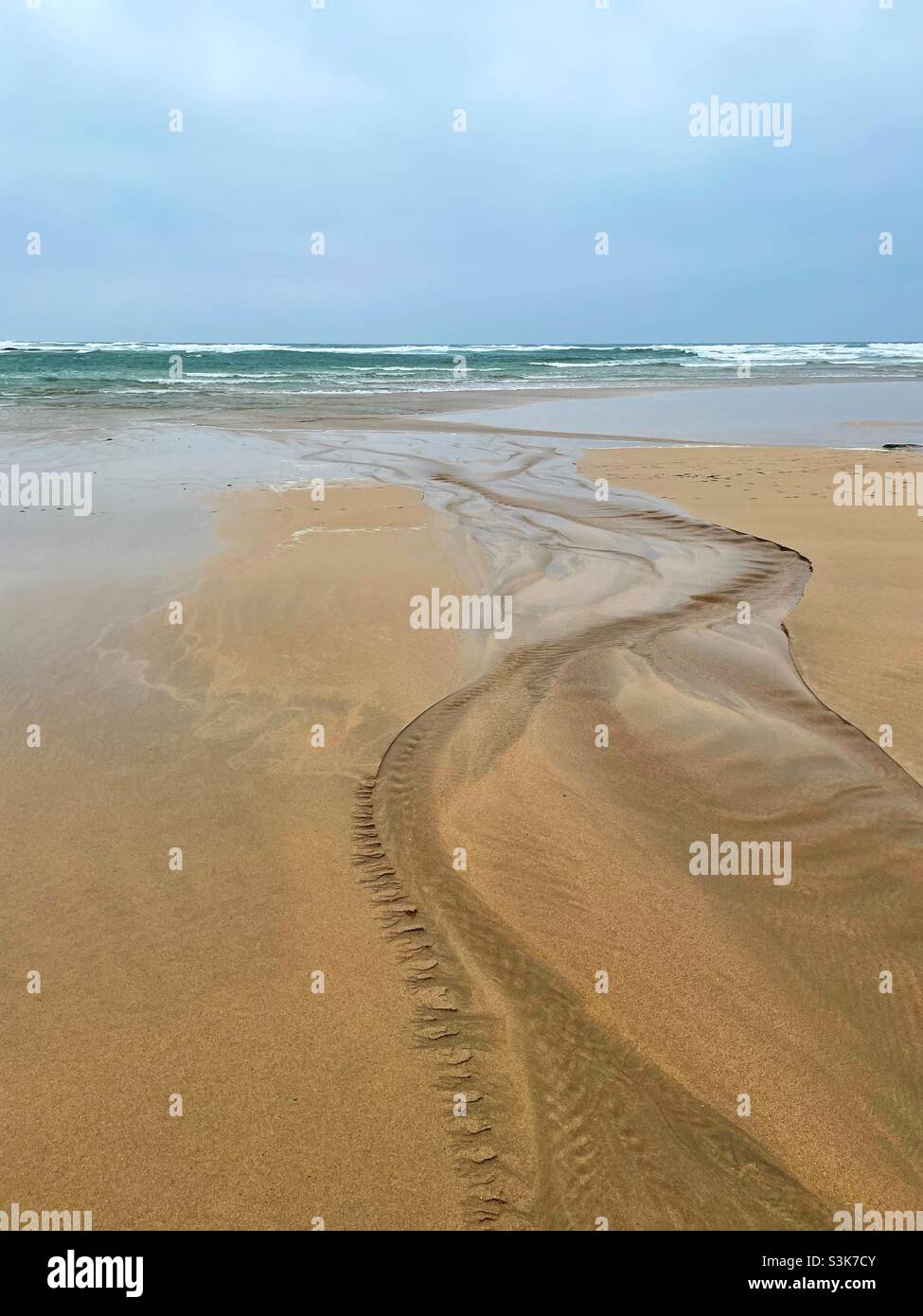 Stream entering the sea on Constantine bay, North Cornwall, October, low tide. - Smartphone Captured Stock Image