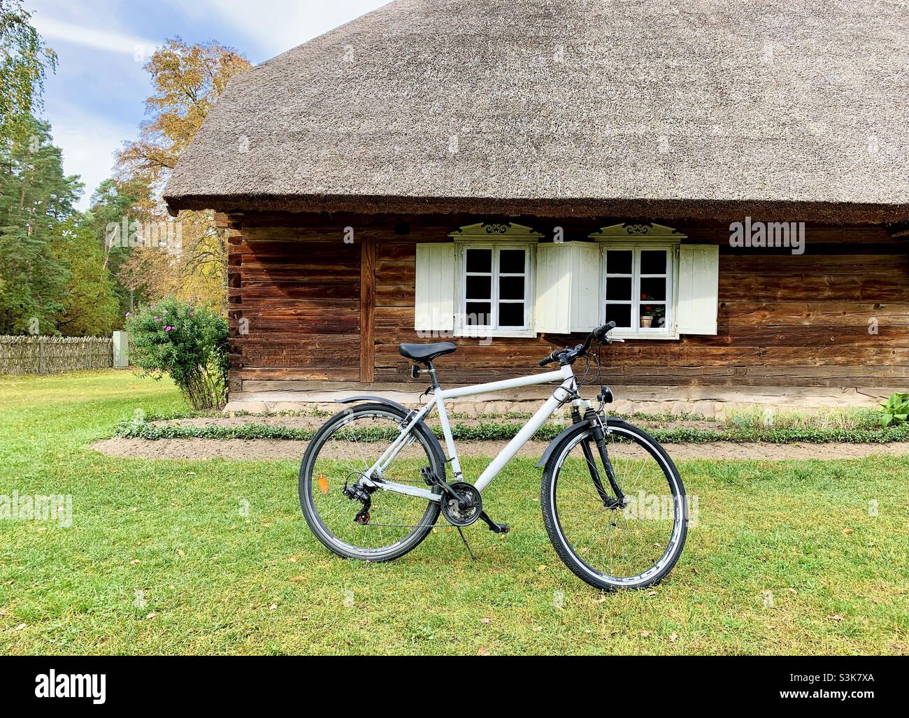 Modern bicycle in front of old wooden country house - Smartphone Captured Stock Image