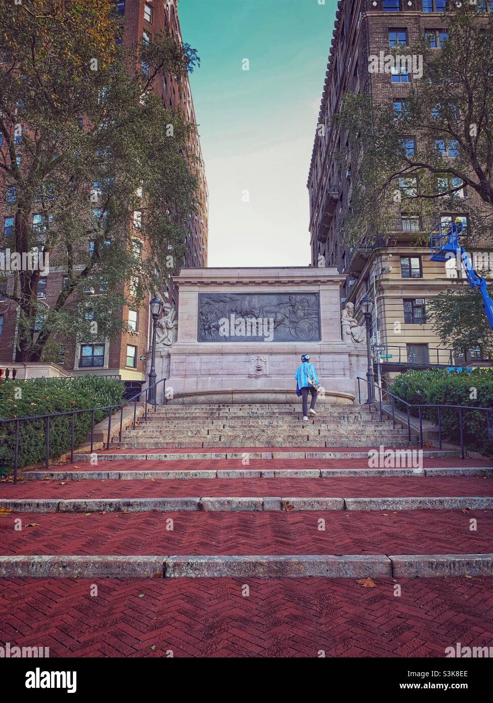 Firemen’s memorial, Manhattan, New York City. A man walking carrying his skate board. - Smartphone Captured Stock Image