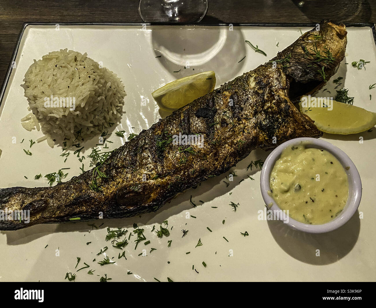 Grilled whole Sea Bass served with rice Stock Photo Alamy