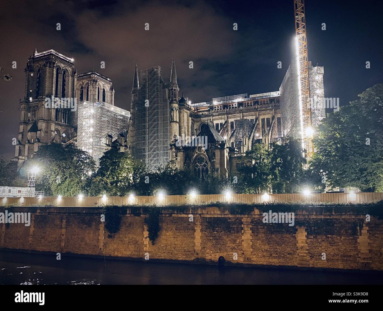 Notre Dame de Paris (Our Lady of Paris) Cathedral under repair/renovation at night after the catastrophic fire of 2019. Paris, France - Smartphone Captured Stock Image