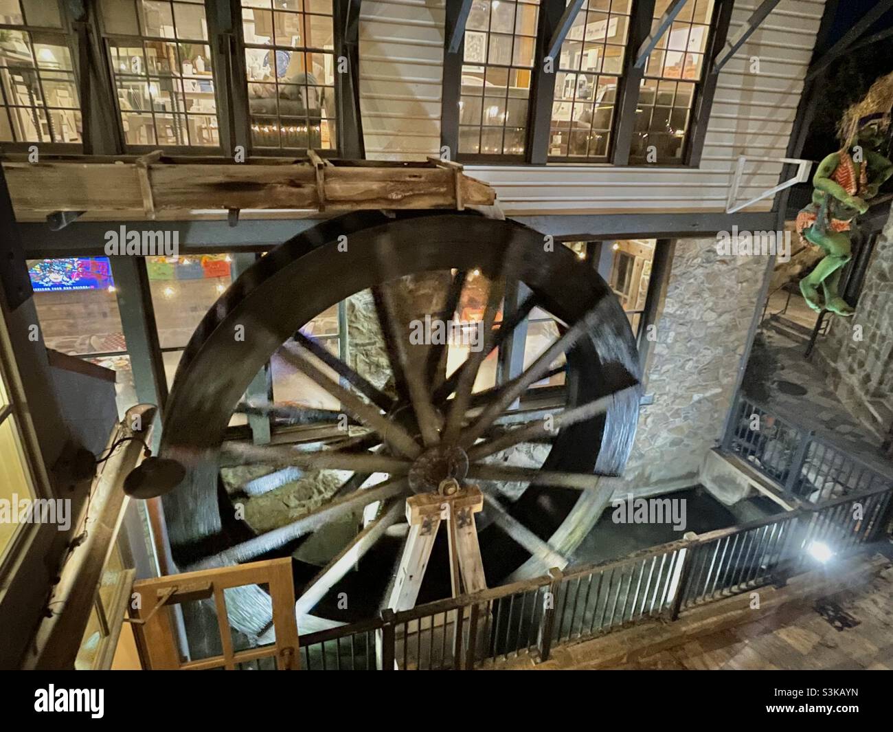 Creative Halloween and Fall decor amidst old-fashioned charm is found at Gardner Village, Utah, USA each October. Here, a working waterwheel churns in front of some shop windows. - Smartphone Captured Stock Image