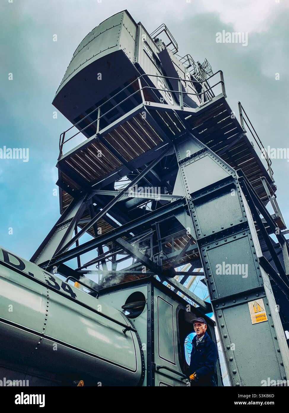 Low angle view of a stream train and its driver under a crane in Bristol - Smartphone Captured Stock Image
