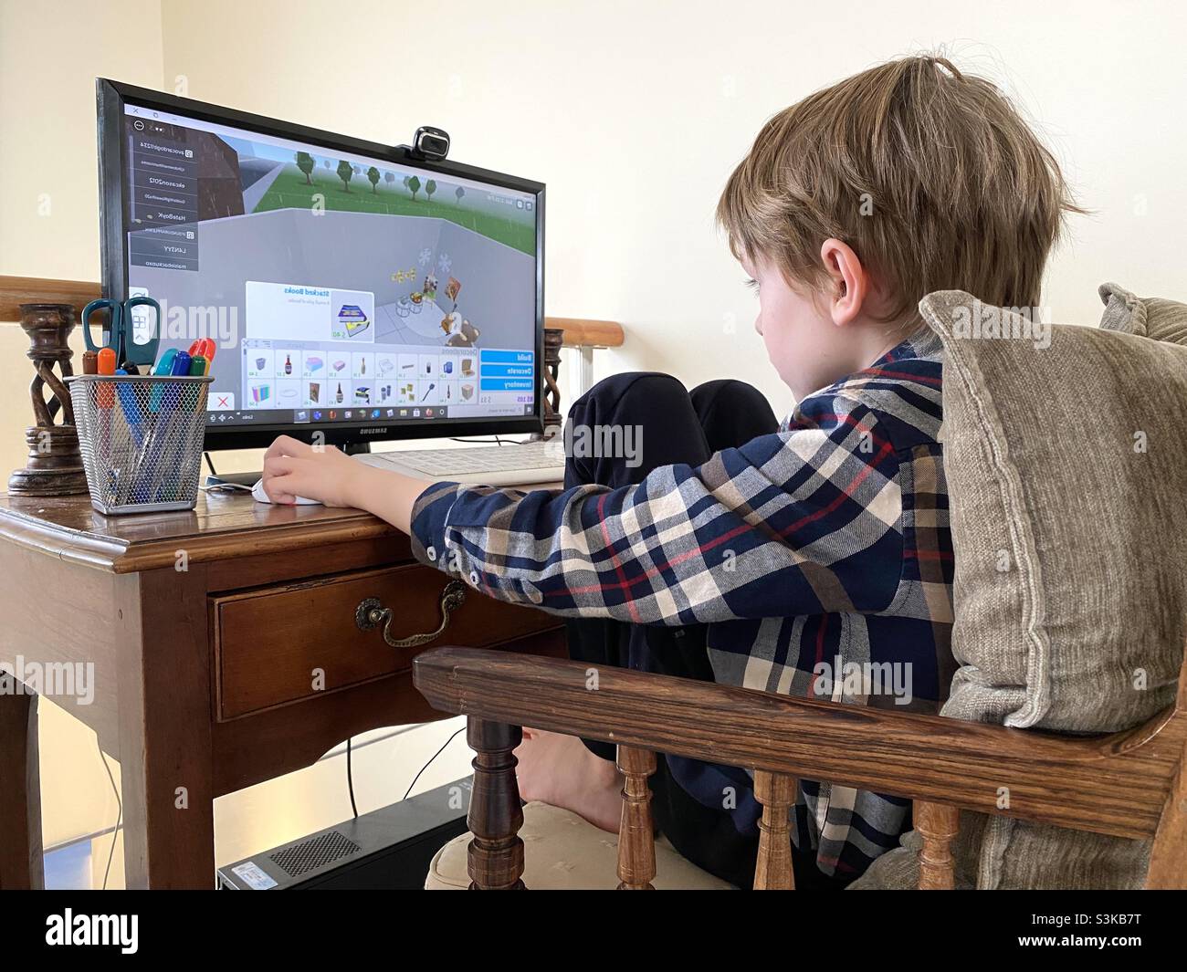 man with a controller standing in front of a PC console TV screen with a  steam controller playing popular free to play game Roblox Stock Photo -  Alamy