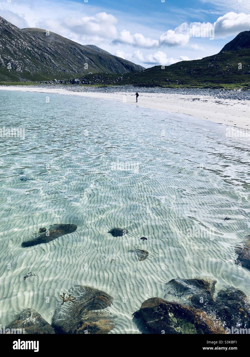 The crystal clear waters and a white sandy beach on Harris in the outer Hebrides in Scotland - Smartphone Captured Stock Image