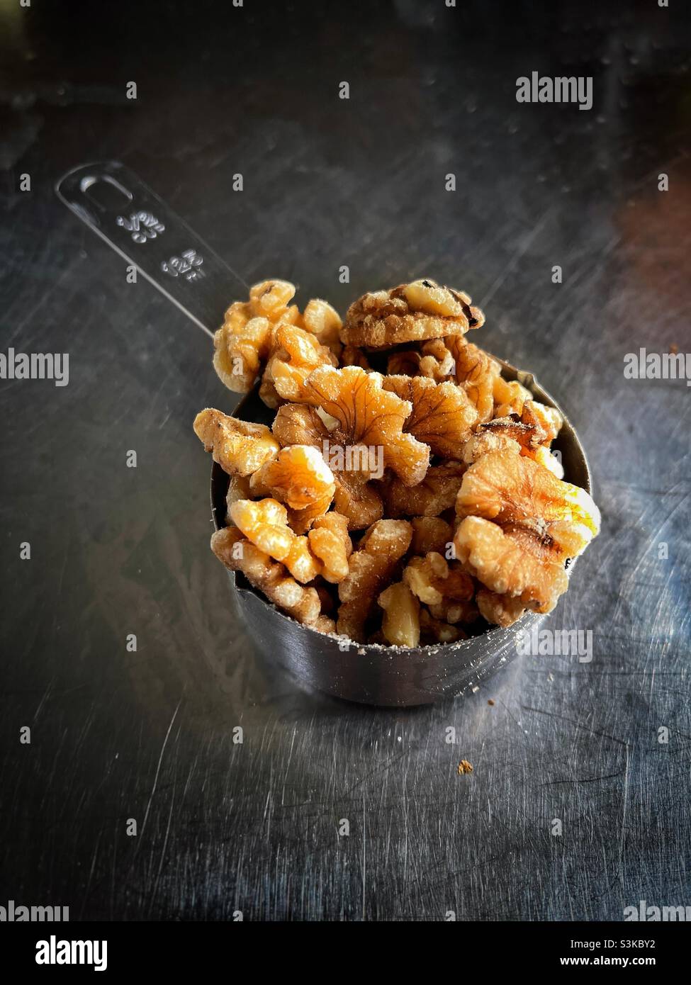 Walnuts in measuring cup in kitchen - Smartphone Captured Stock Image