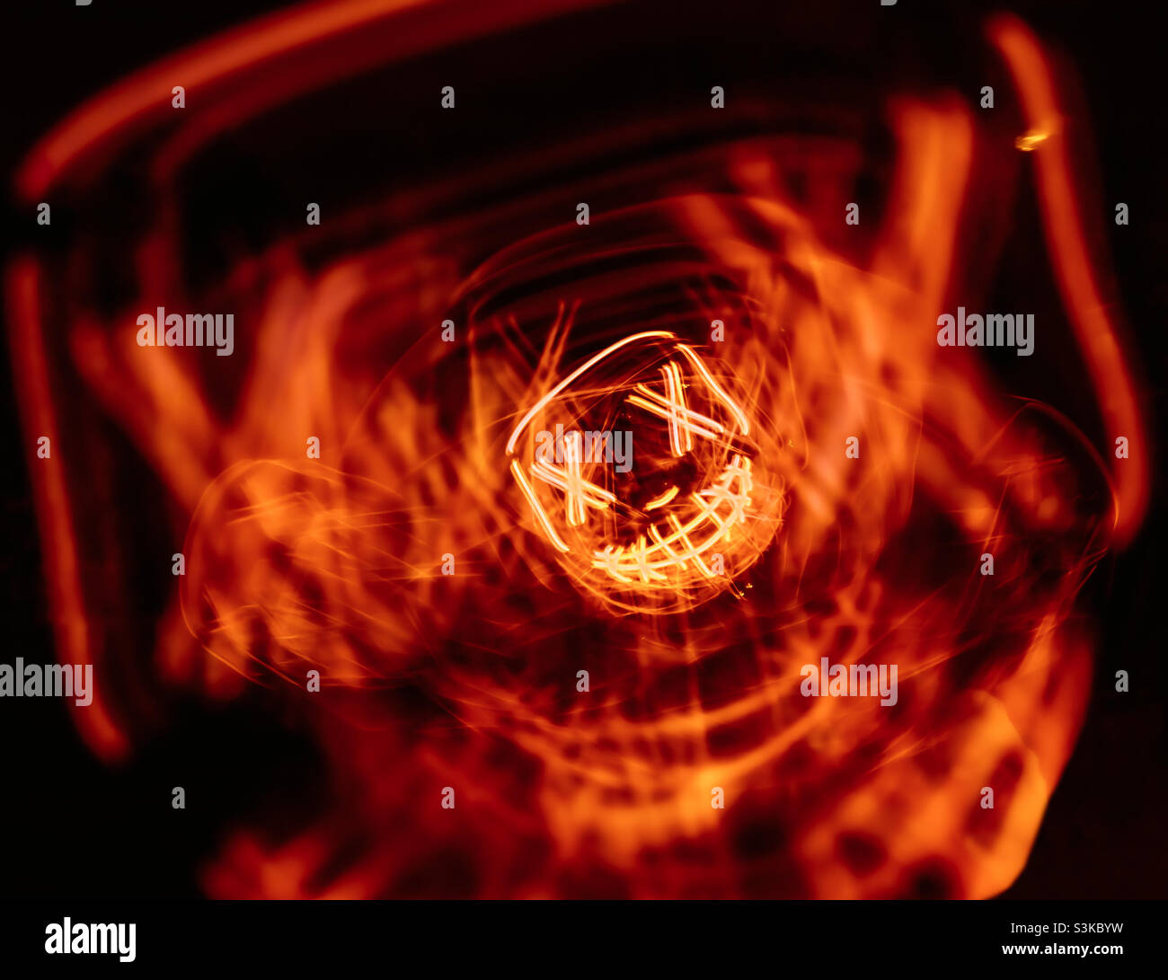 Long exposure of a person wearing an led Halloween mask, in orange and black - Smartphone Captured Stock Image