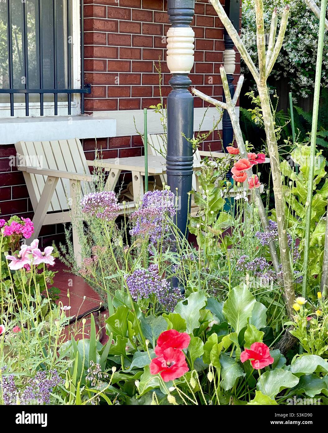 Timber Table Snd Chairs On The Verandah And A Cottage Garden Stock