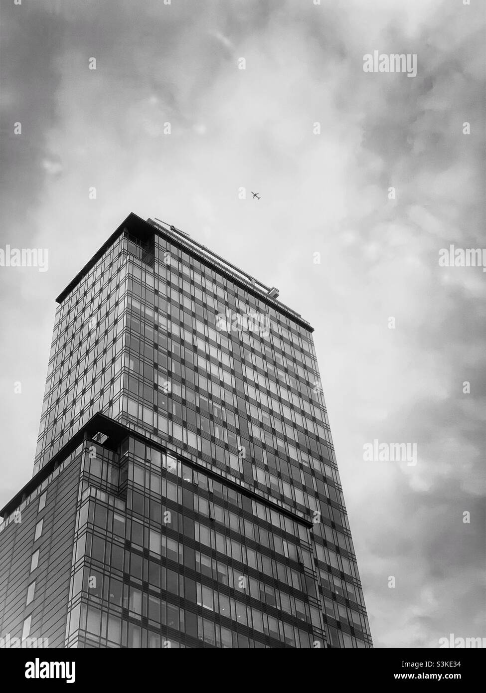 A building and airplane in black and white. - Smartphone Captured Stock Image