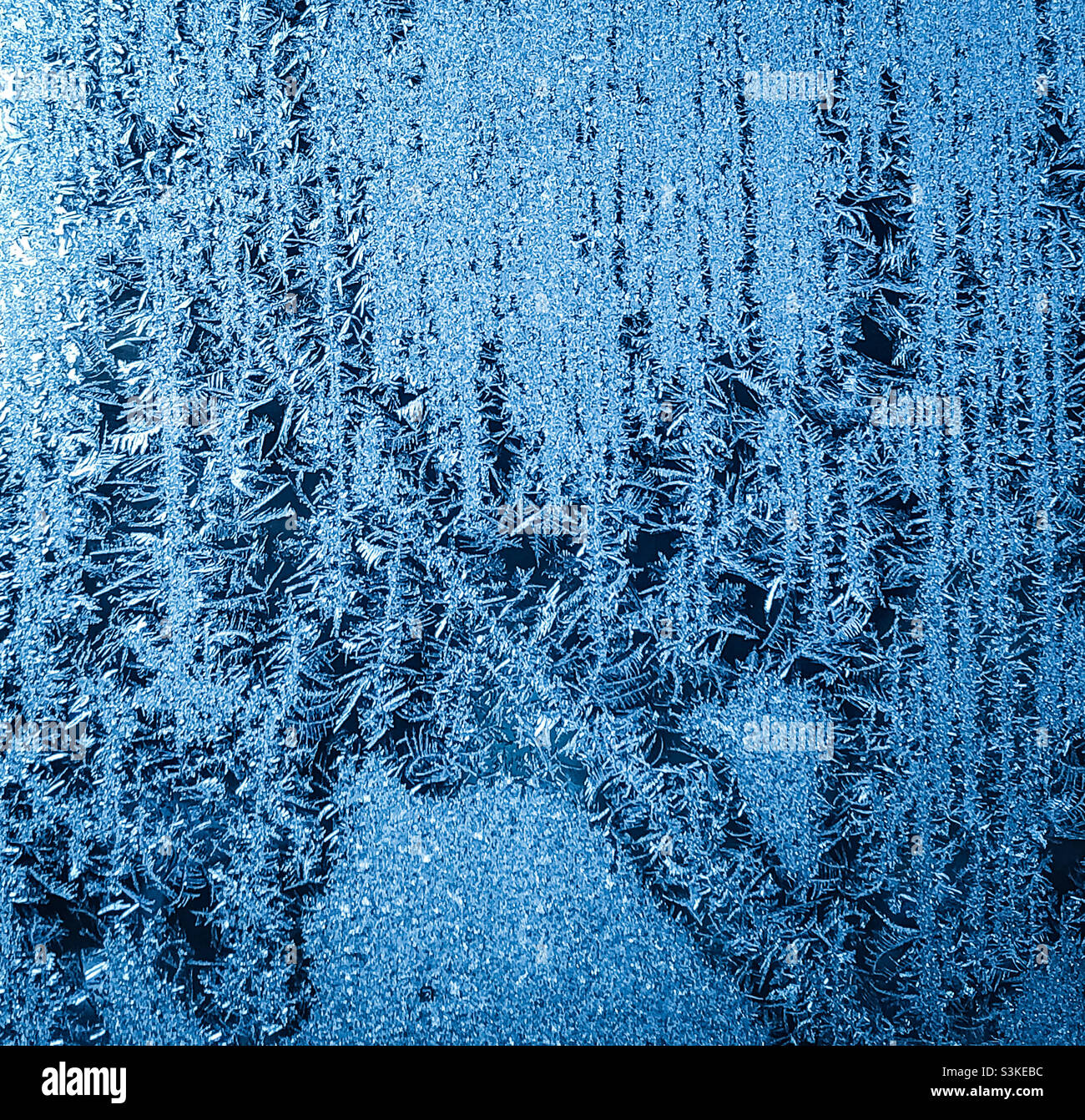 A frosted window covered in tiny icicles Stock Photo