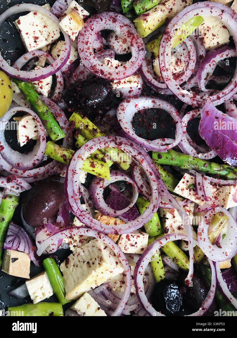 Vegan dish consist of red onions tofu asparagus and olives Stock Photo