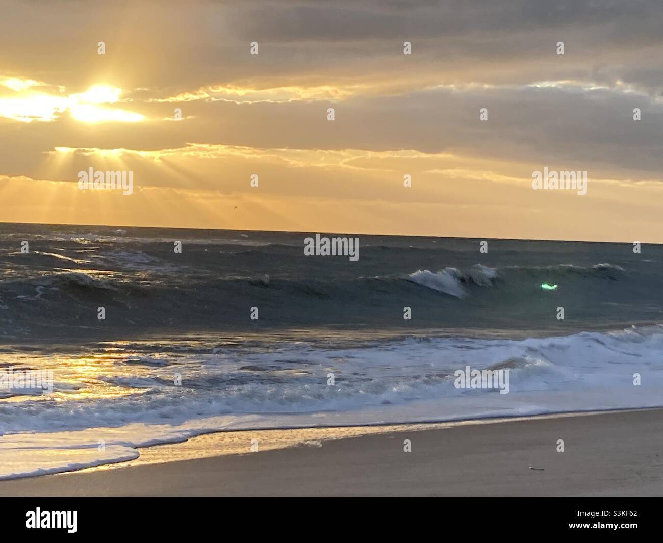 Sunrise with rays through clouds over ocean - Smartphone Captured Stock Image