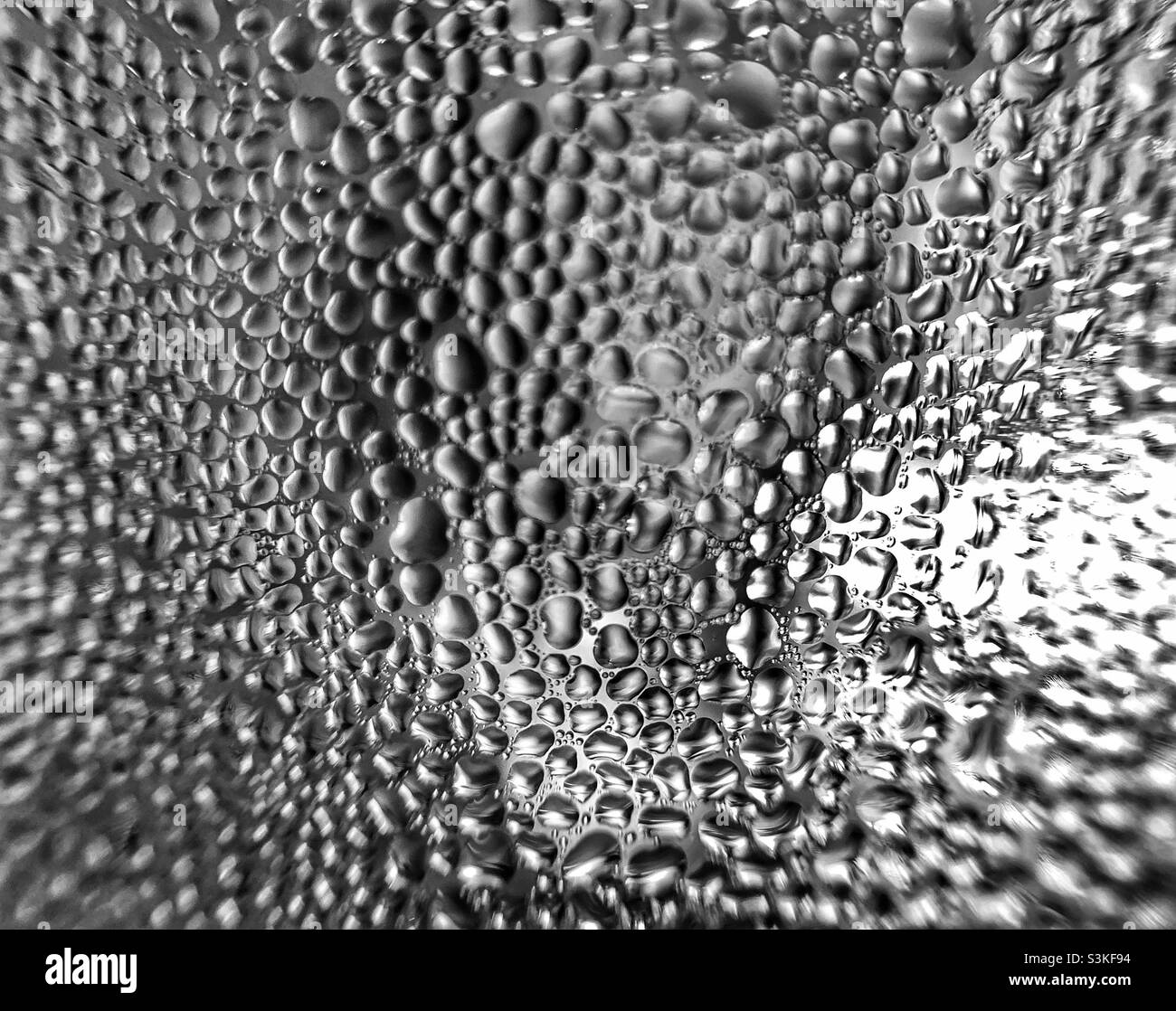 Macro shot of moisture outside of transparent glass in black and white. - Smartphone Captured Stock Image