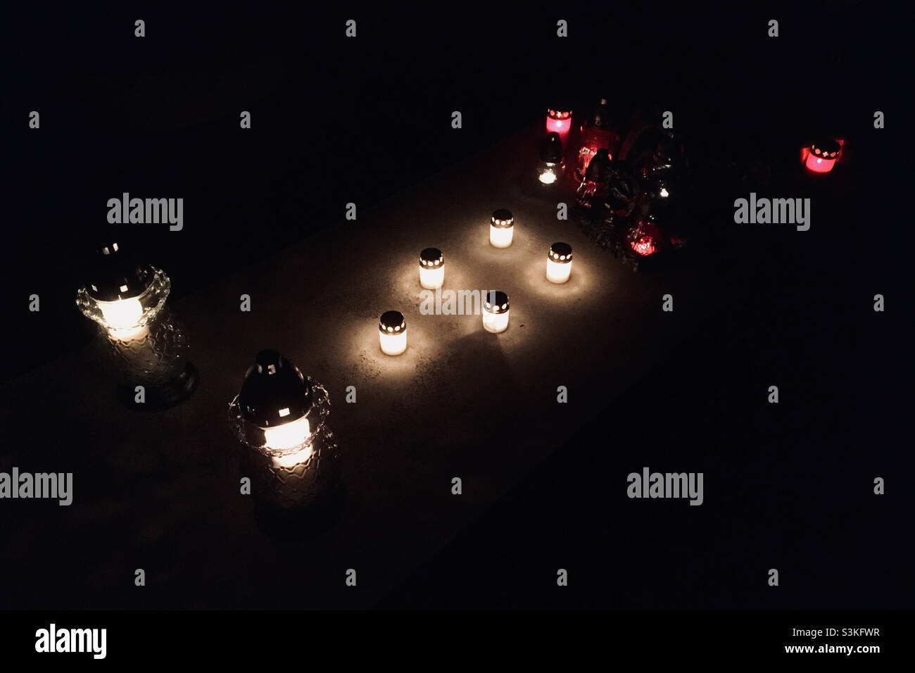 Candles burning on gravestone in cemetery on All Saints Day - Smartphone Captured Stock Image