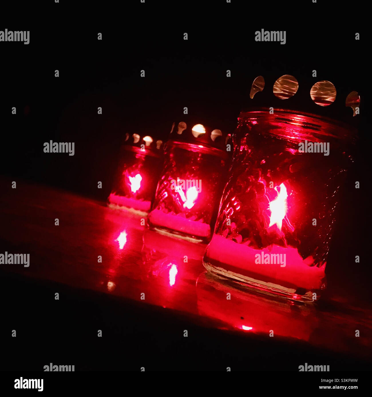 Candles burning on gravestone in cemetery on All Saints Day at night - Smartphone Captured Stock Image