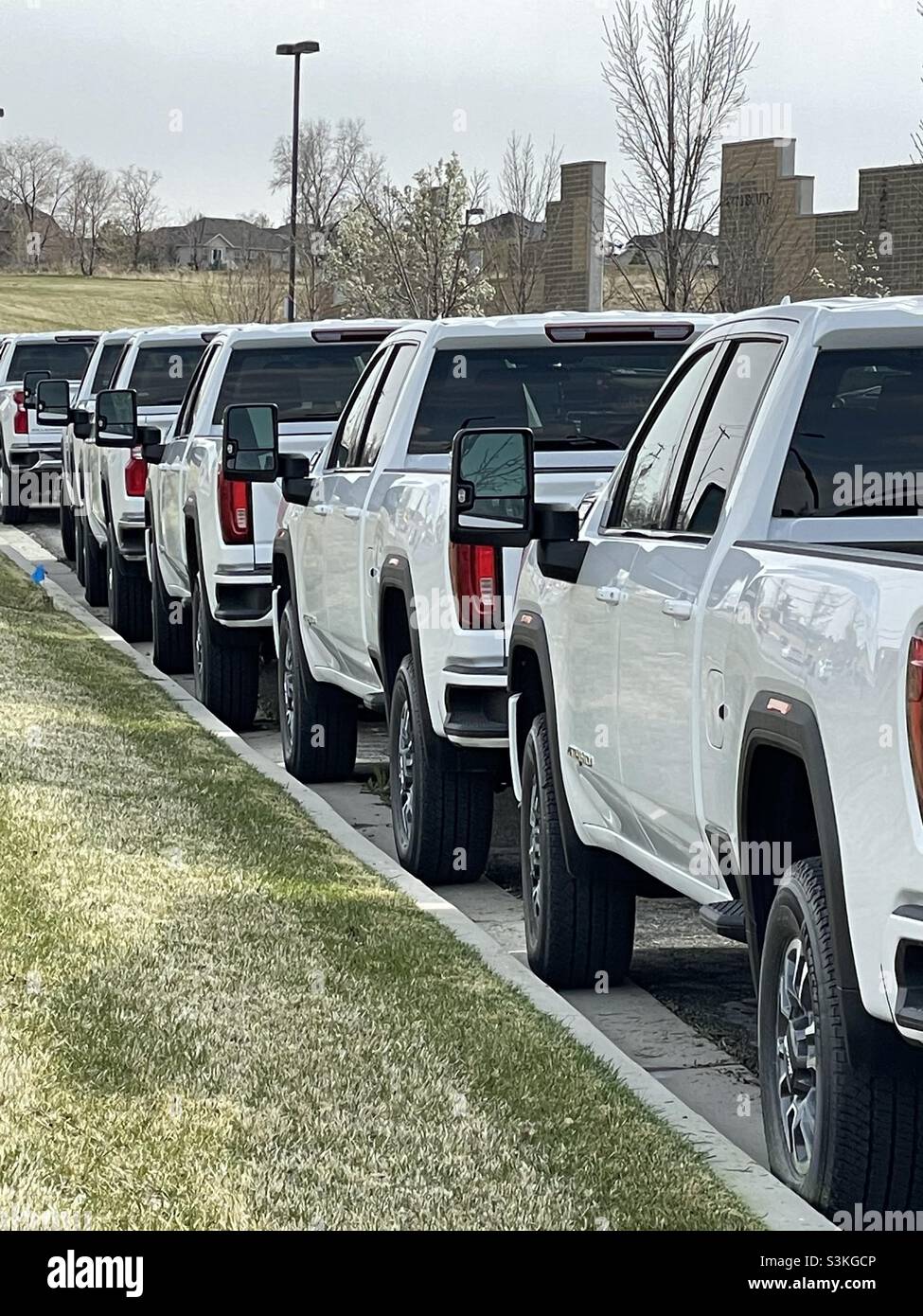 New GMC trucks lined up at a dealership, ready for sale. Stock Photo