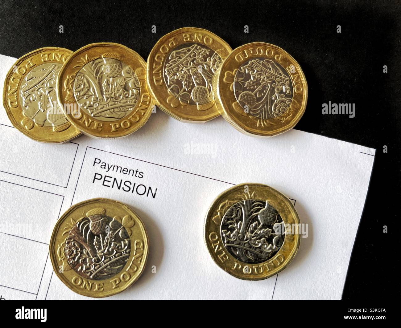 One pound coins on top of an anonymous pension payment slip Stock Photo