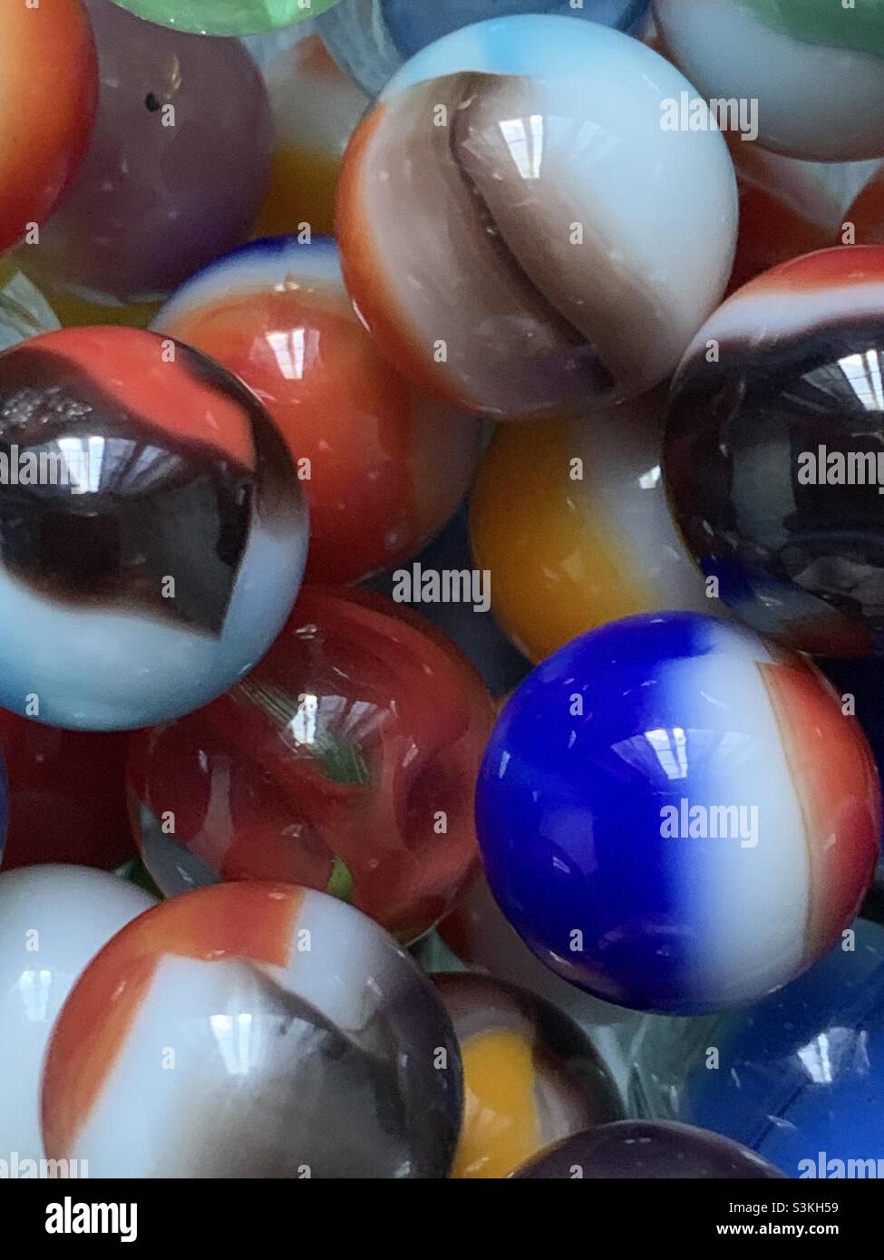 A grouping of old-fashioned marbles, like the ones I remember playing with growing up in the 60s. - Smartphone Captured Stock Image