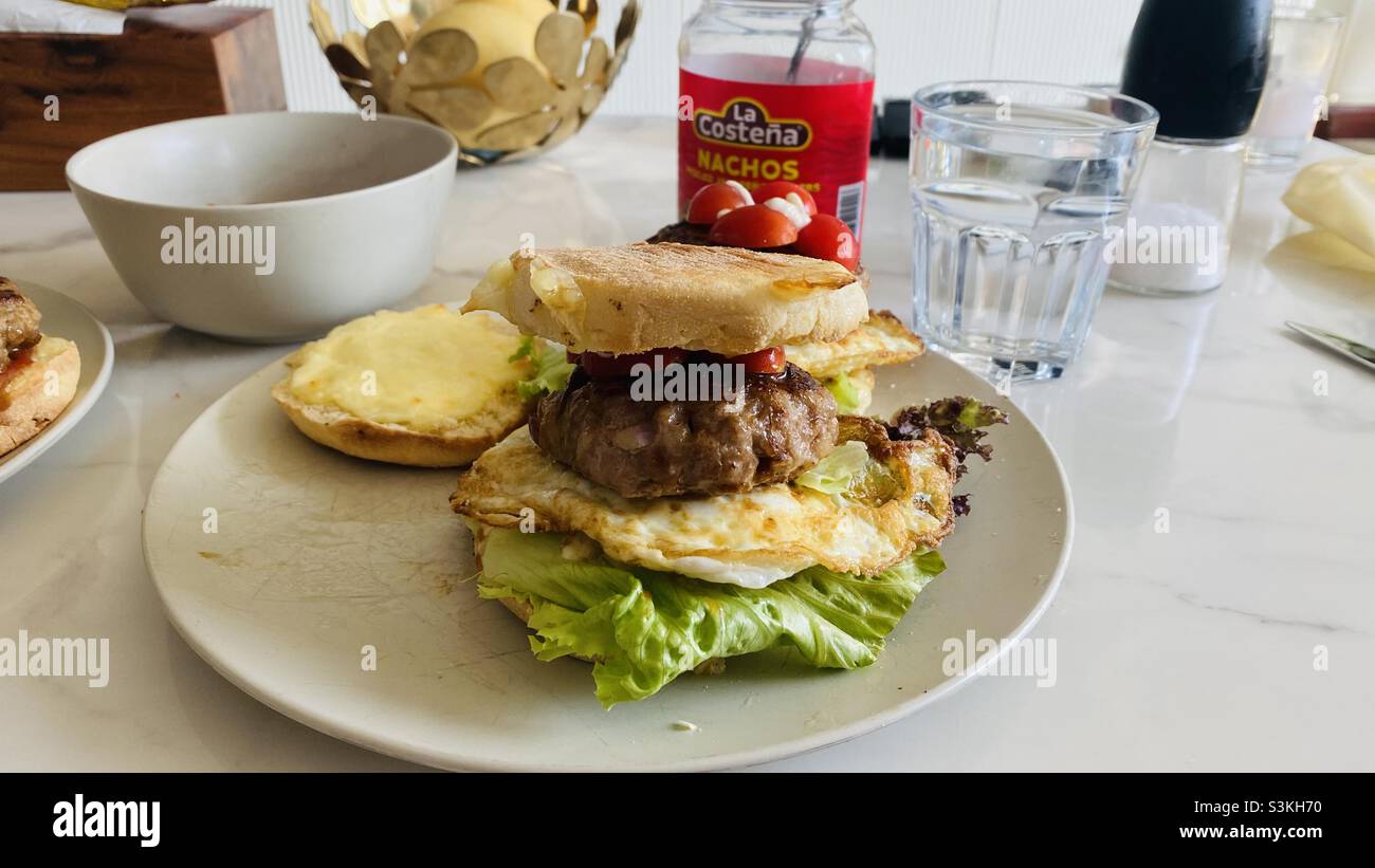 British muffins with pork burger and fried eggs Stock Photo
