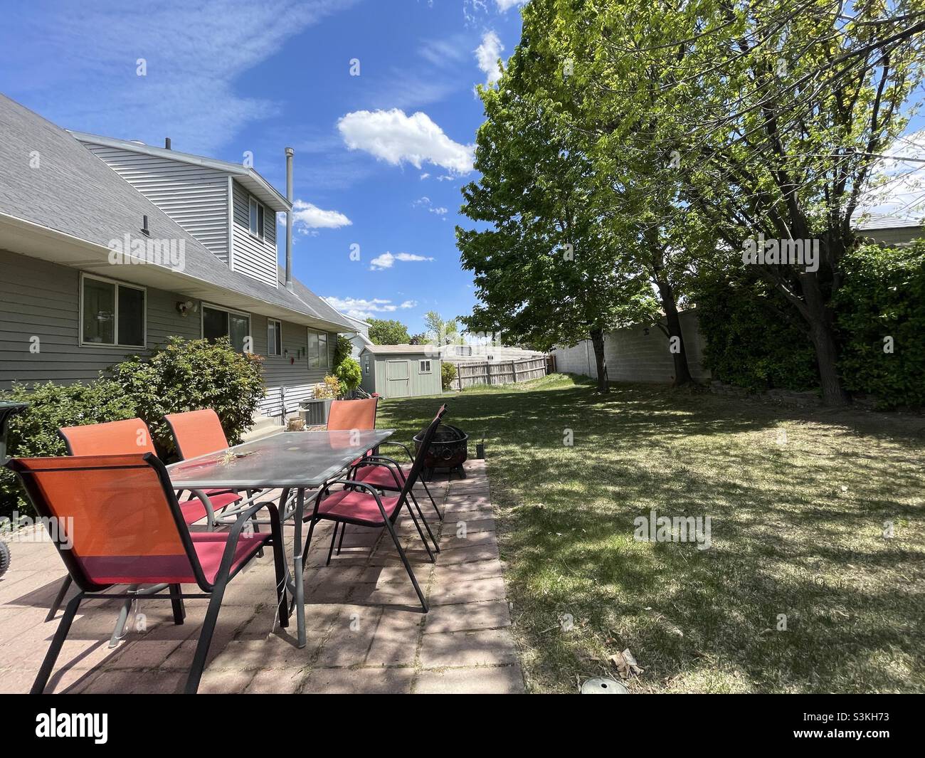 A wide view of a backyard and patio in the summertime in Utah, USA. - Smartphone Captured Stock Image