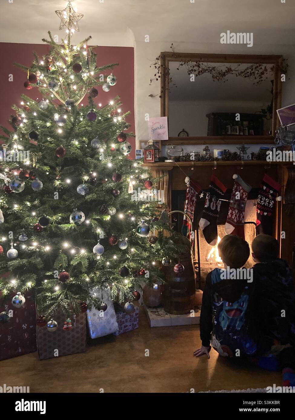 Christmas tree with two children sending their letter to Santa up the chimney Stock Photo Alamy