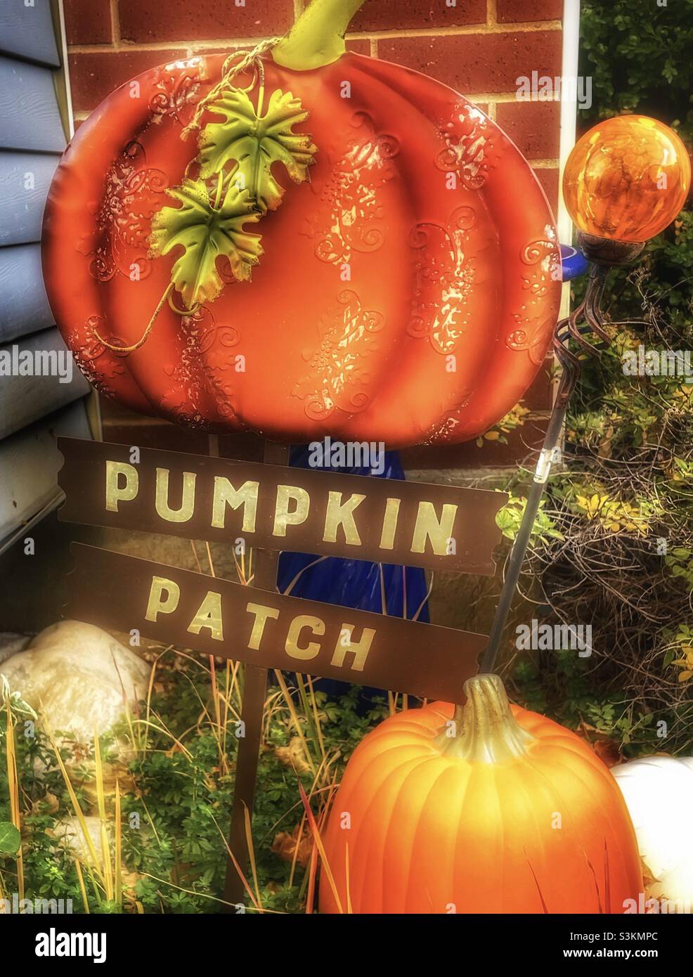 Yard decor helps bring the fall season to this home garden in northern Utah, USA. - Smartphone Captured Stock Image