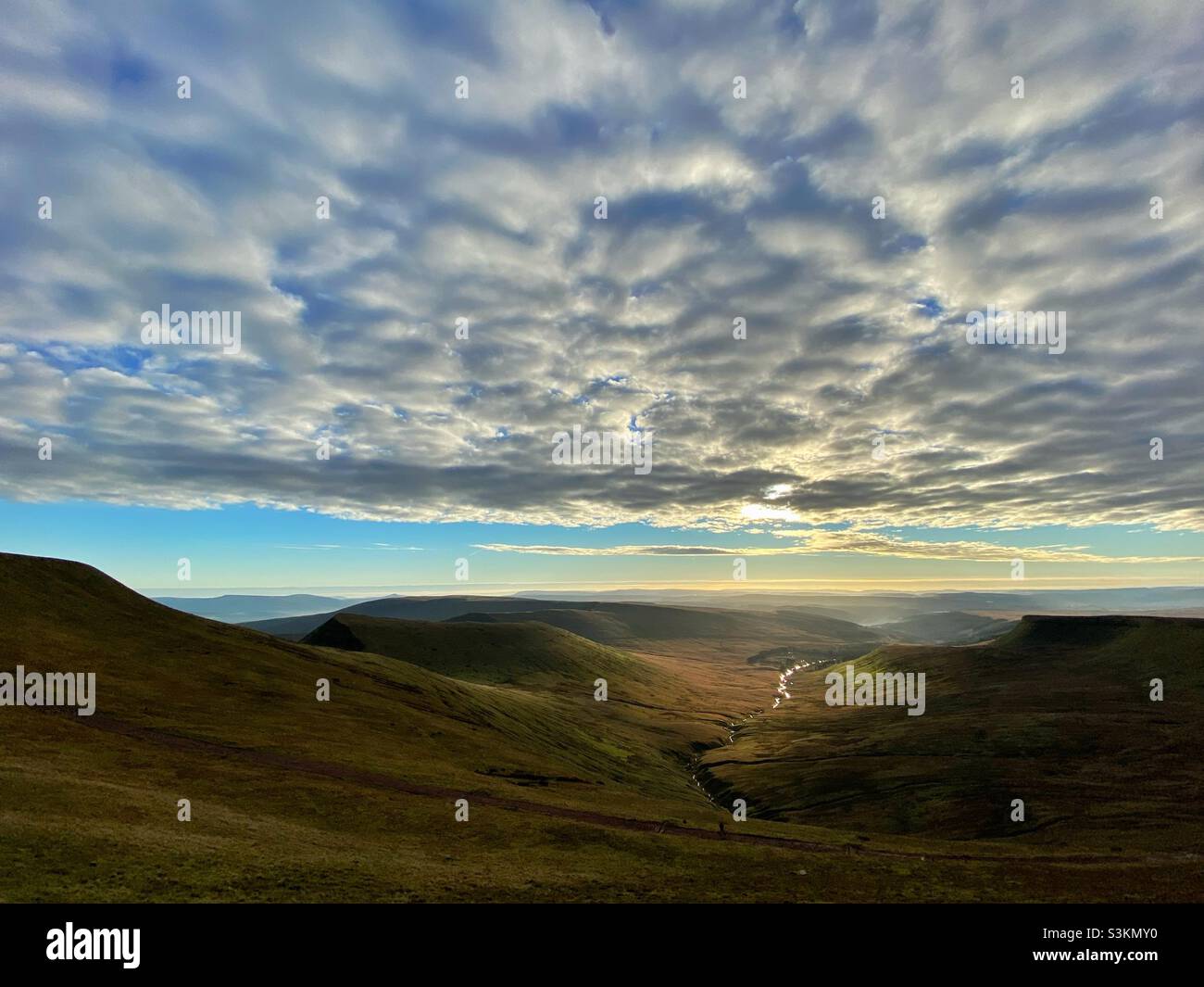 A photograph from Pen y Fan mountain looking out across the valley with a river glinting silver below - Smartphone Captured Stock Image A photograph from Pen y Fan mountain looking out across the valley with a river glinting silver below - Smartphone Captured Stock Image