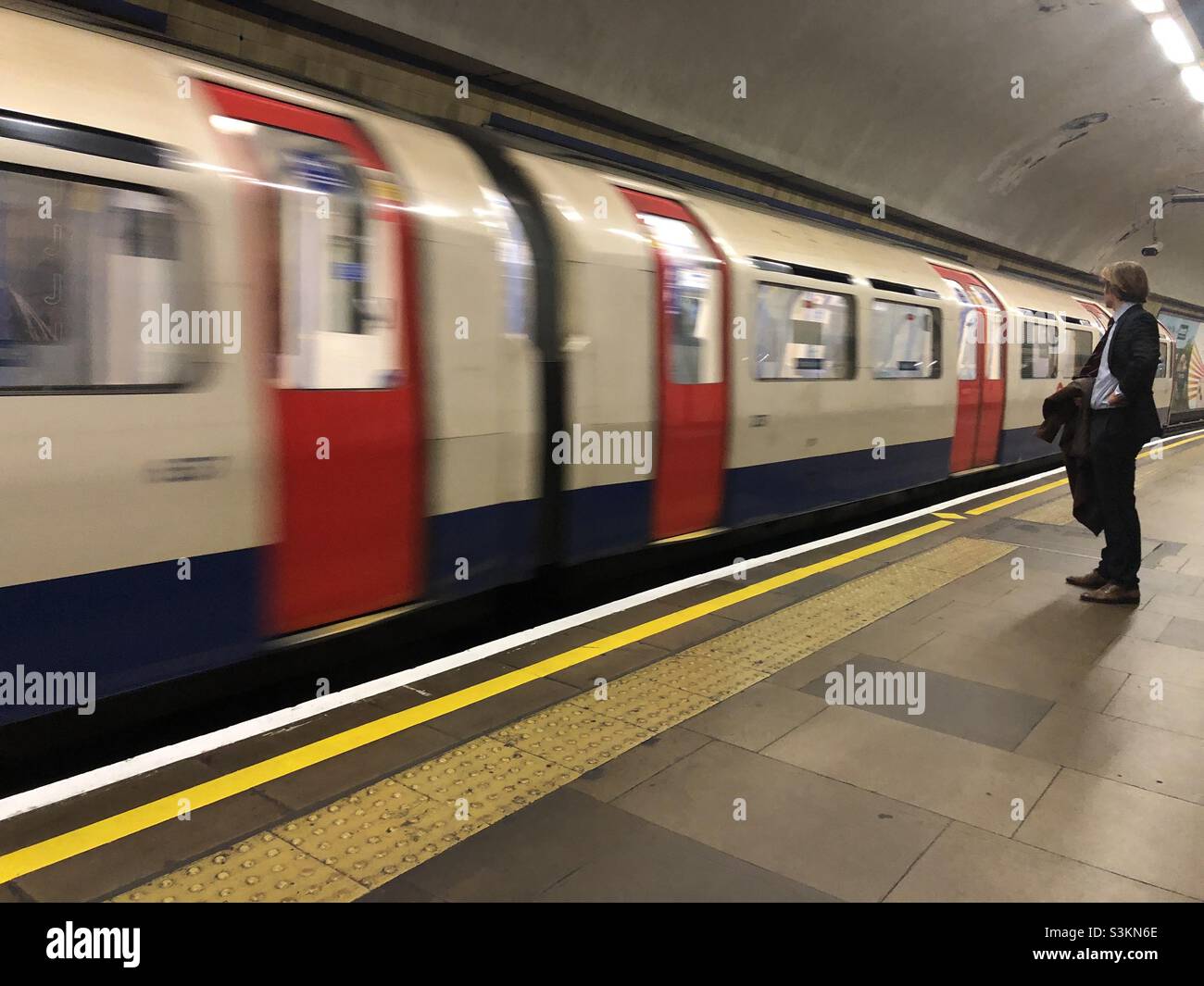 Man in suit waiting for a London Underground tube train - Smartphone Captured Stock Image