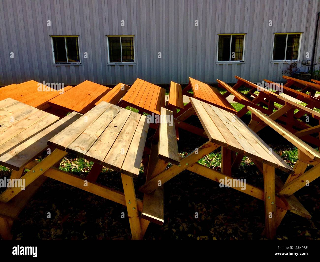 Picnic tables stacked for winter, outdoors, Ontario, Canada outside a portable structure. Four windows. - Smartphone Captured Stock Image