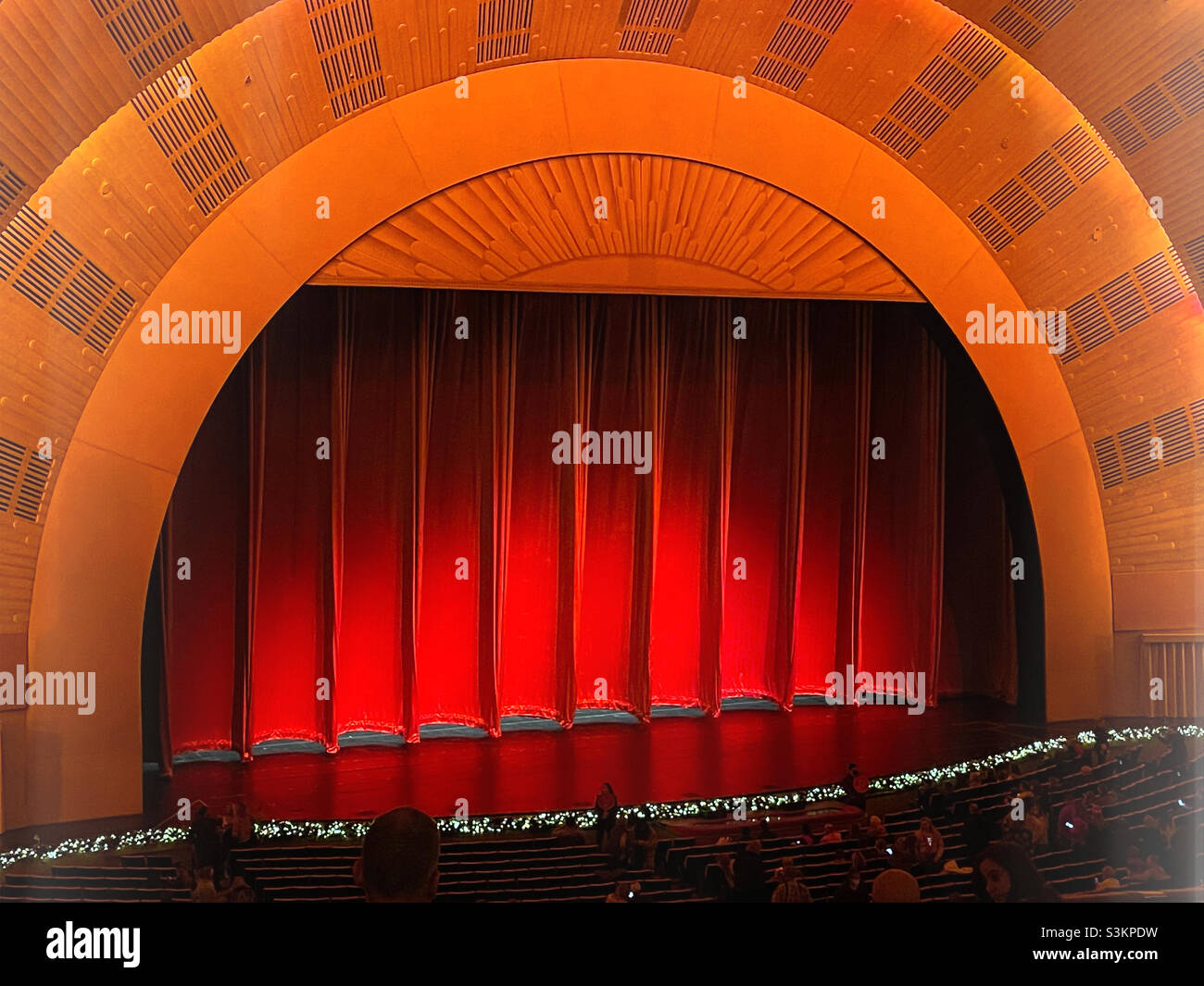 Radio city music Hall in Rockefeller Center features a huge red curtain on its stage, 2021, United States, New York City - Smartphone Captured Stock Image