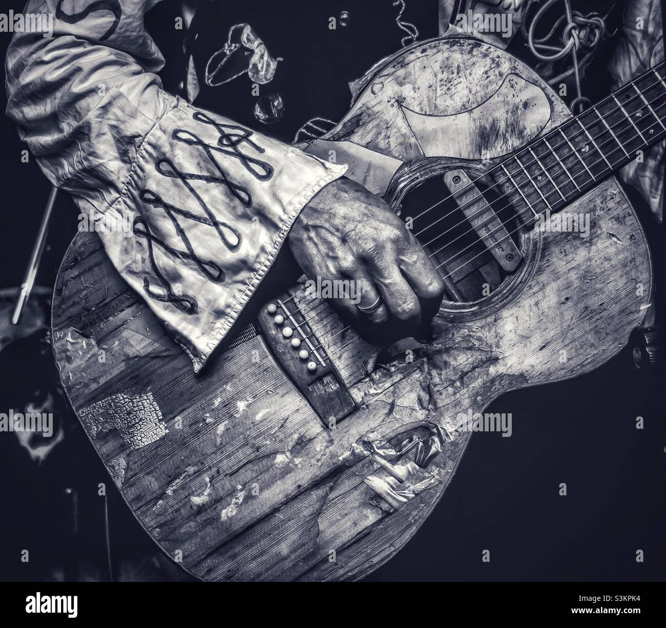 Ed Tudorpole plays his old, beat up acoustic guitar, close up of hand and  guitar in monochrome Stock Photo - Alamy
